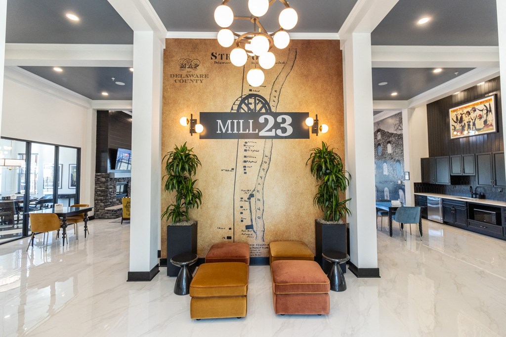 the lobby of mill 23 with couches and a wall with a sign on it