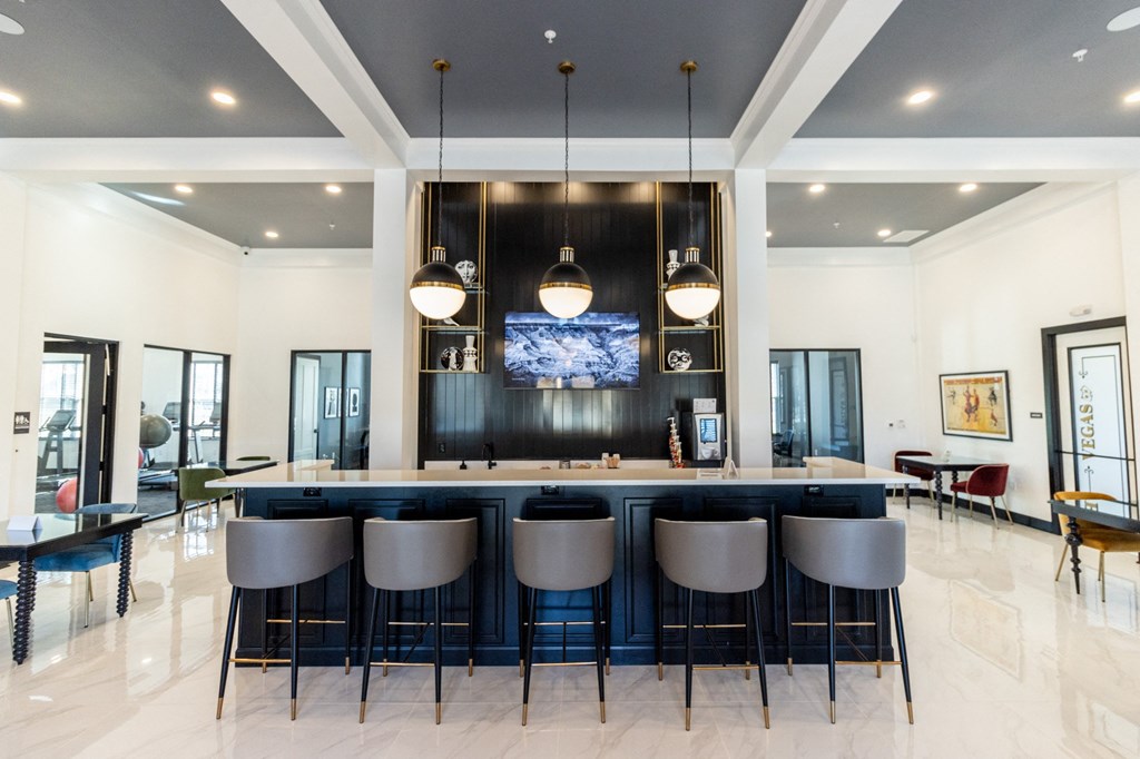 a large kitchen with a bar and chairs in front of it