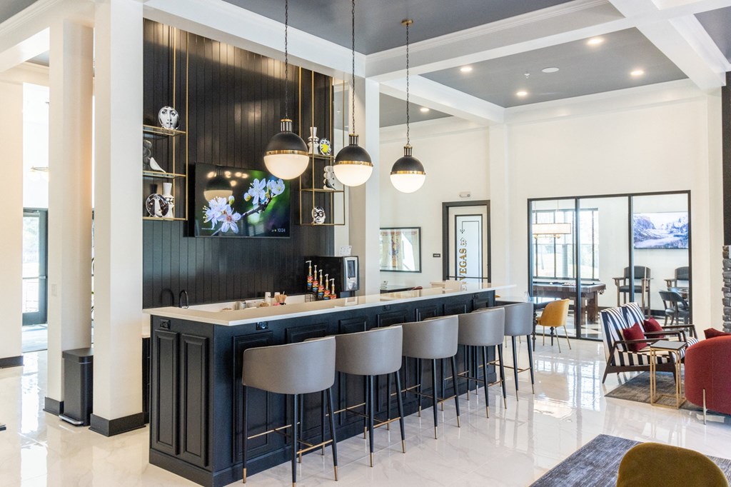a bar with bar stools in a living room with a dining table and chairs