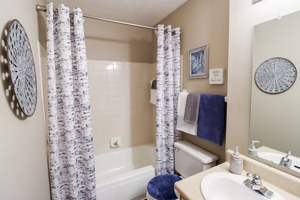 a bathroom with a shower curtain and a sink and a toilet
