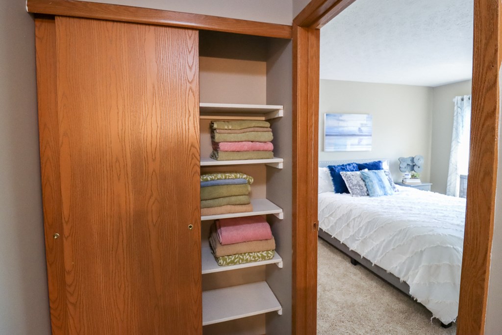 a bedroom with a closet with shelves and a bed