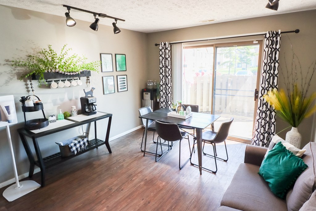 a living room with a dining room table and a sliding glass door