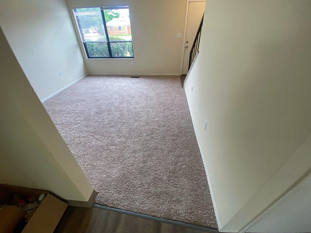 an empty room with a carpeted floor and a window