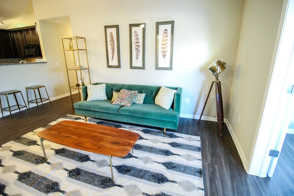 a living room with a green couch and a cowhide rug
