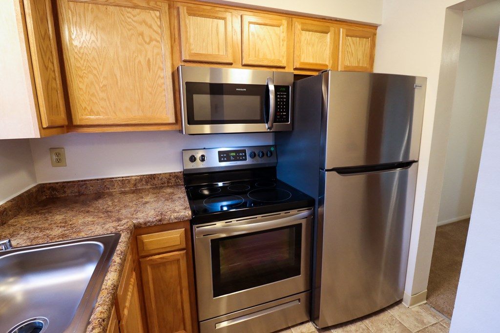 a kitchen with stainless steel appliances and wooden cabinets