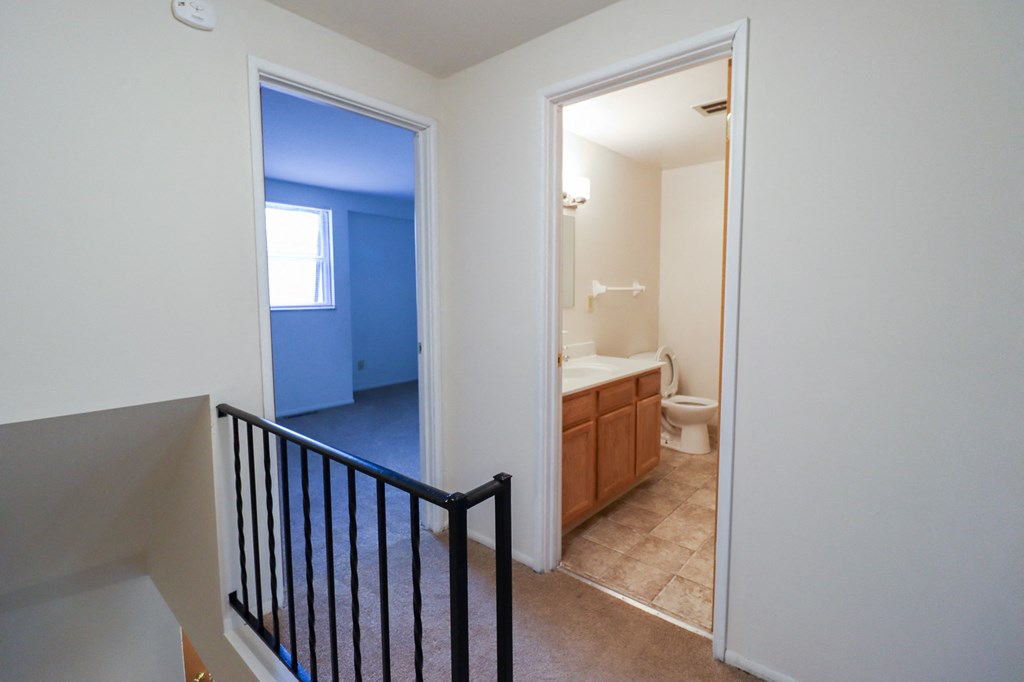 a stairway in a home looking into a bathroom with a toilet and a sink