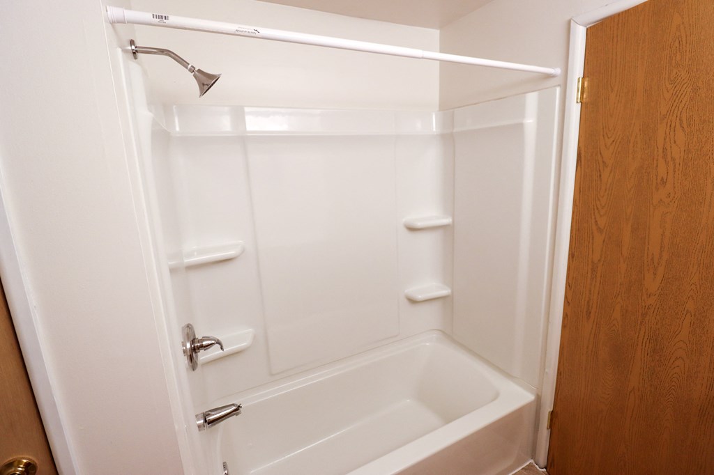 a small white bathroom with a tub and a shower