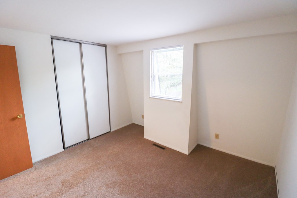 an empty room with white walls and a window