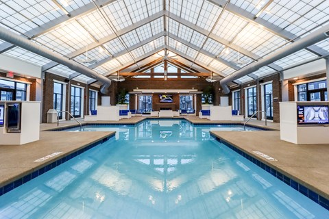 a large indoor swimming pool with a glass ceiling and skylights