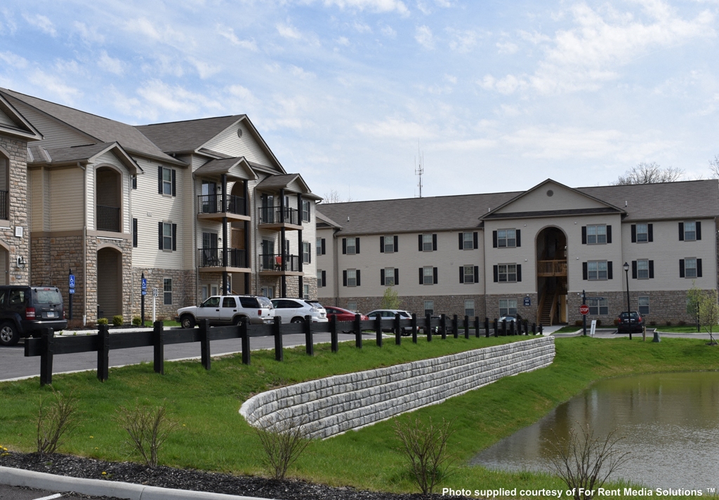 an image of a building with a pond in front of it