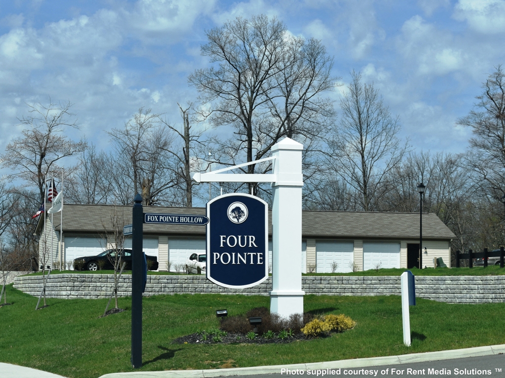 a sign for four pointe in front of a white building