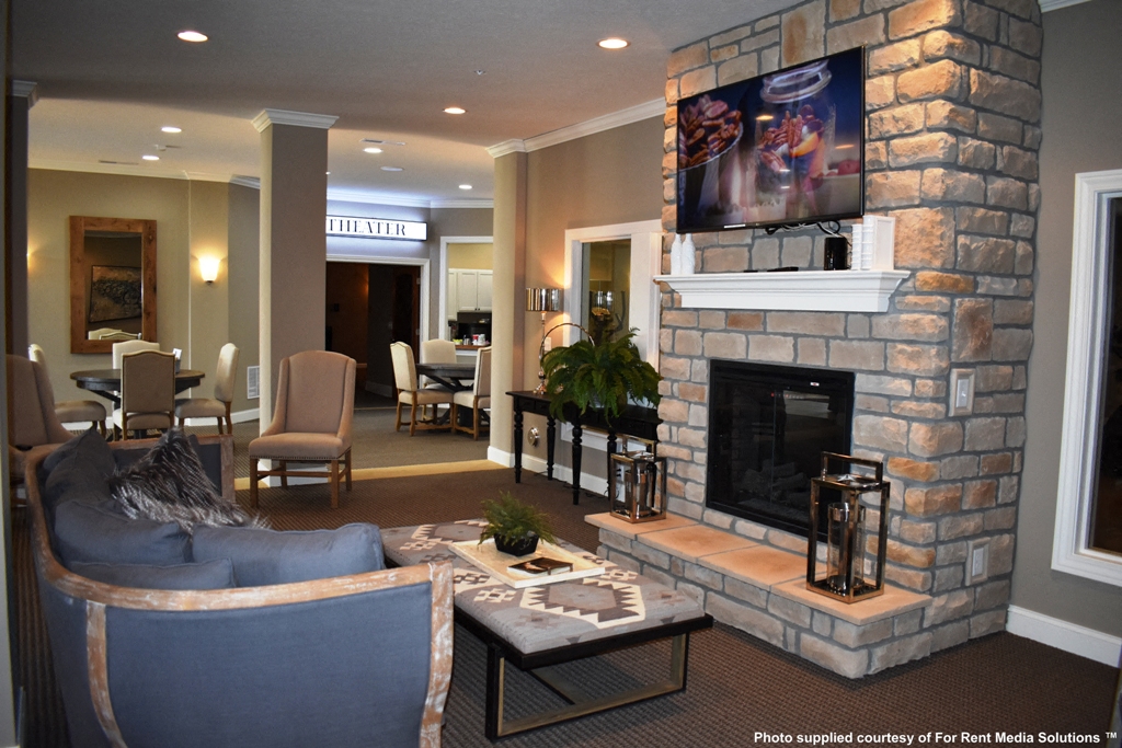 a living room with a stone fireplace and a tv above it