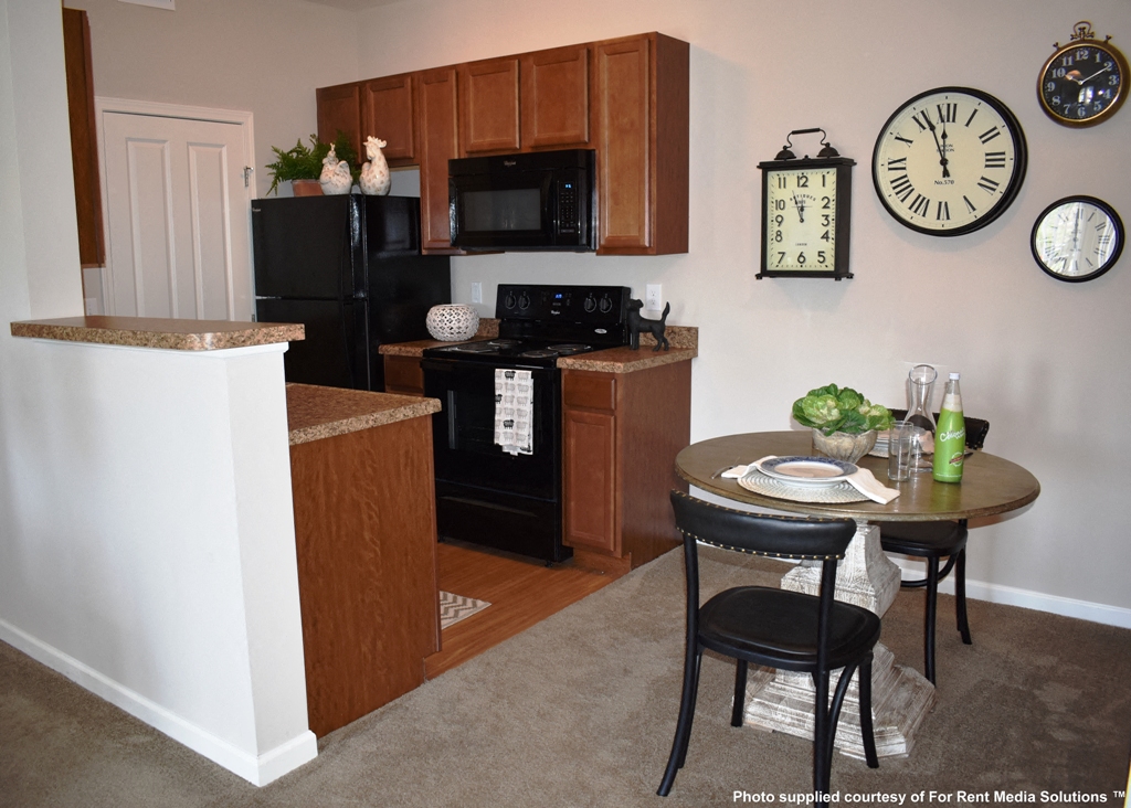 a kitchen with black appliances and a table with chairs