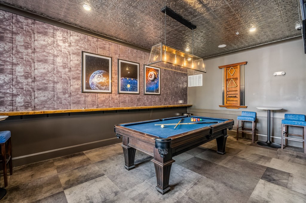 a game room with a pool table and a bar