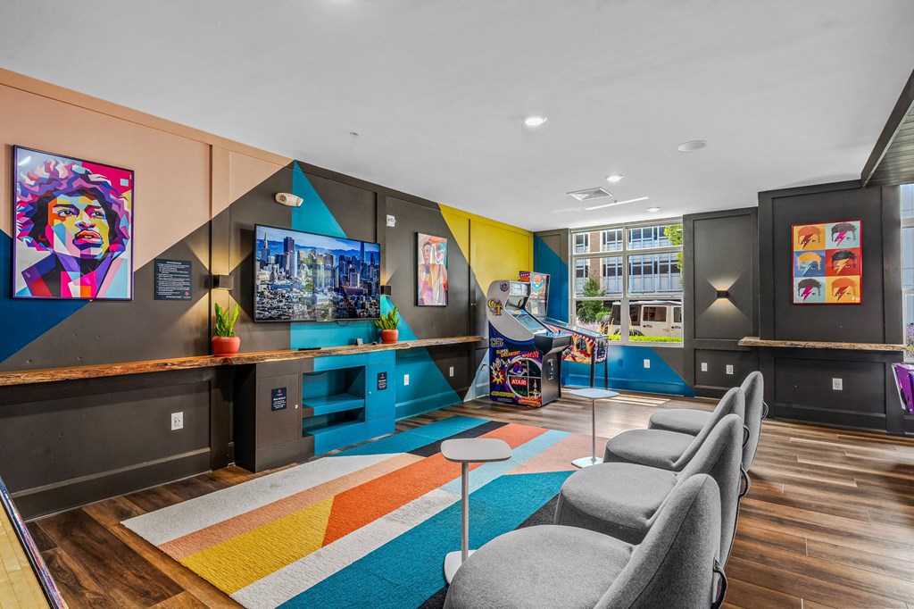 a living room with couches and chairs and a play area with a video game