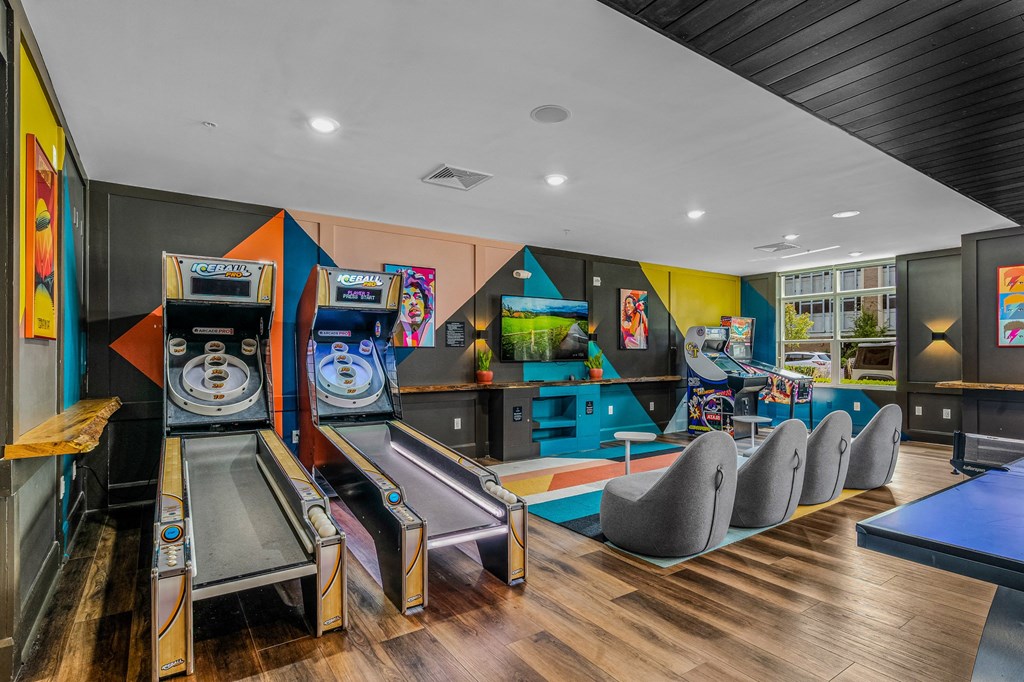 a game room with a bunch of arcade games and chairs