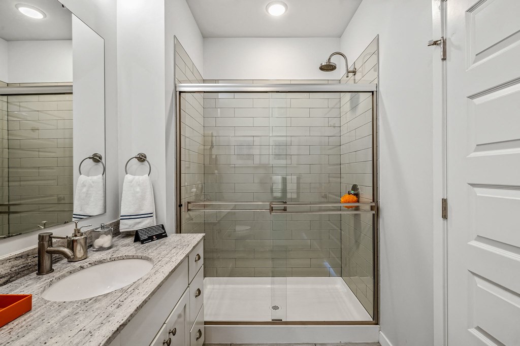 a bathroom with a shower and a sink and a mirror