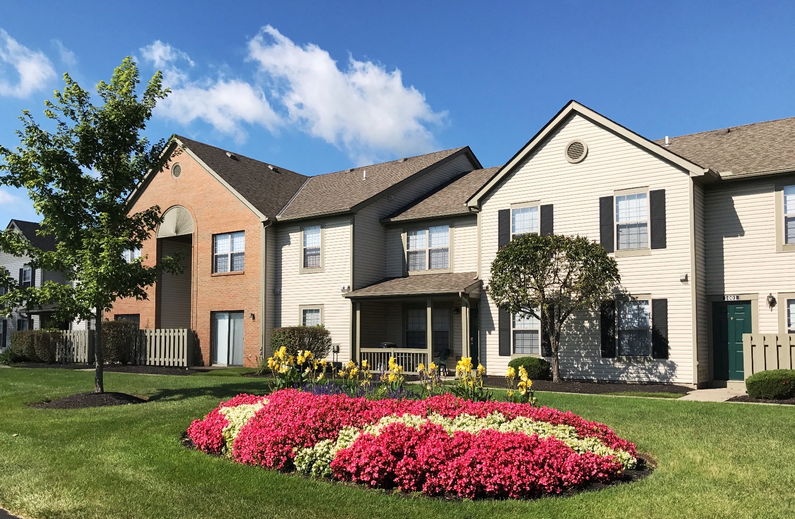 a group of houses with a flower garden in front of them