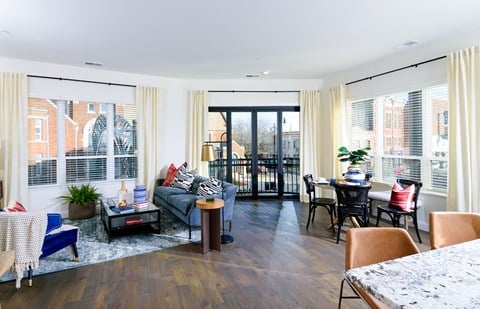 a living room with a couch and a table and a balcony