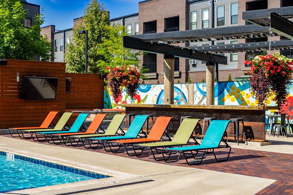 a pool area with lounge chairs and a television