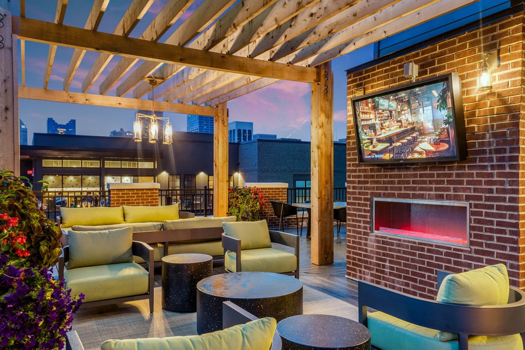 a patio with couches and tables and a fireplace