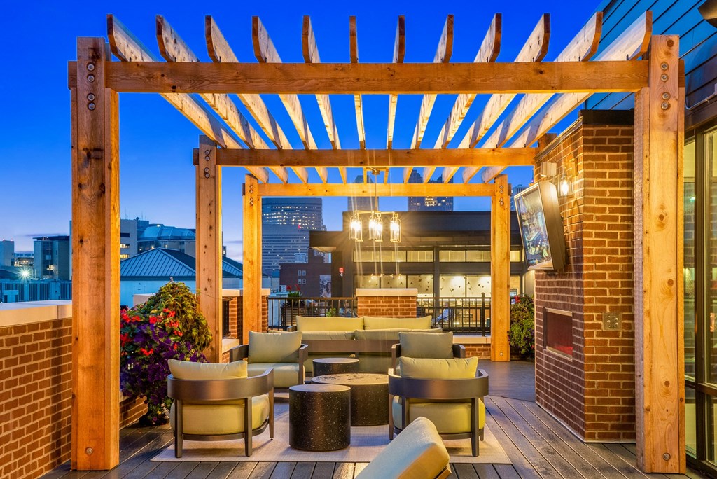 a patio with a fireplace and a wooden pergola