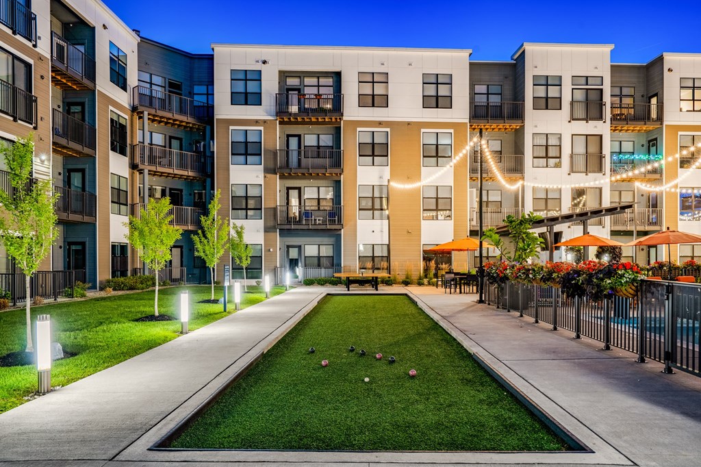 an exterior view of an apartment building with a grassy courtyard
