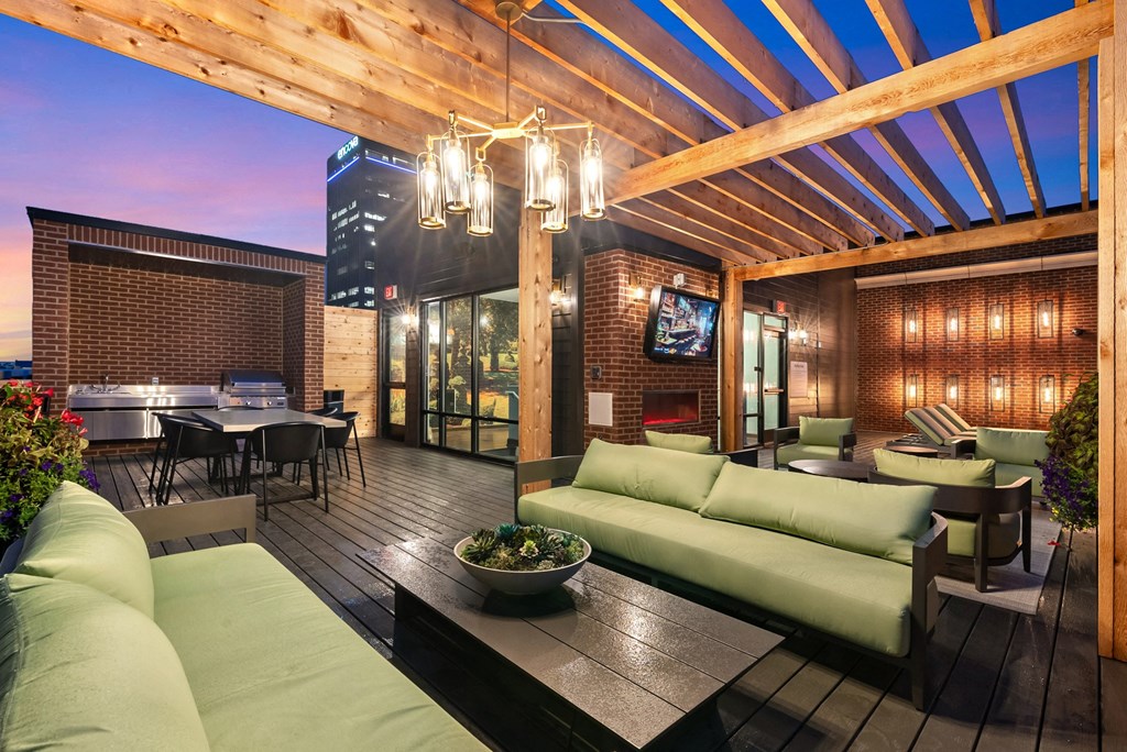 a patio with green couches and chairs and a table and chairs