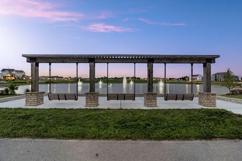 a pavilion with benches in front of a body of water
