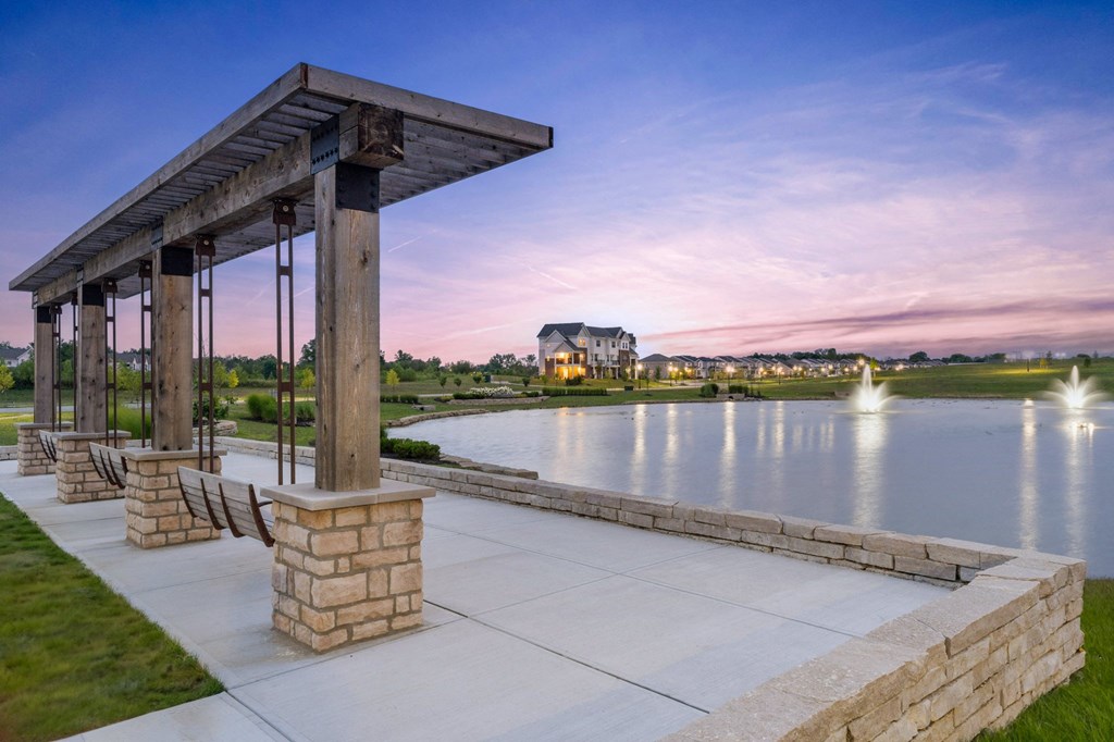 a pavilion overlooking a lake at sunset