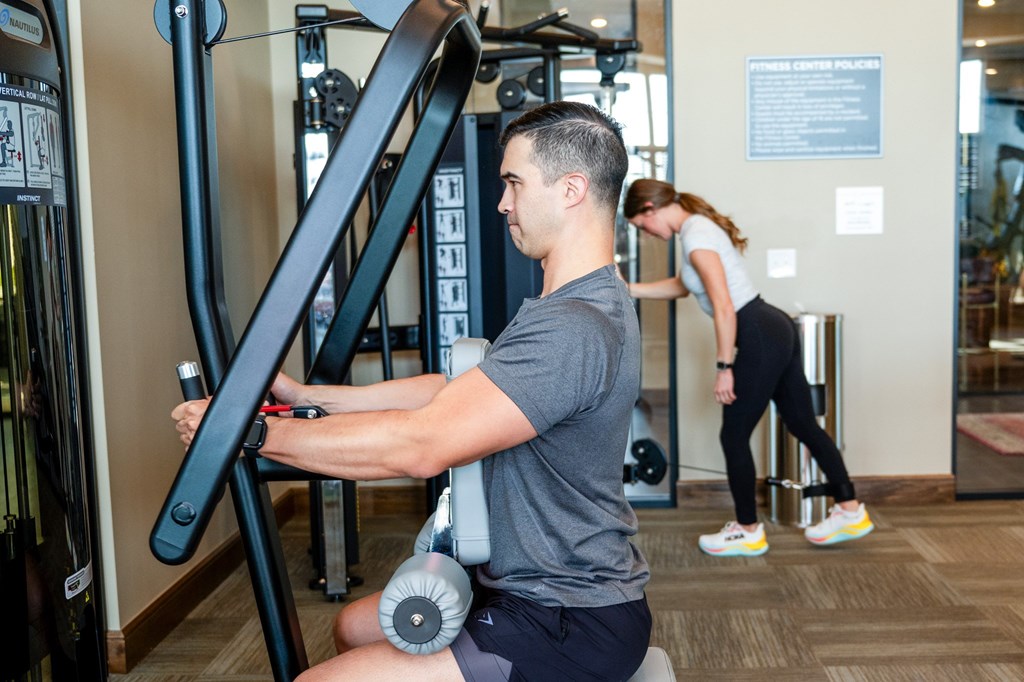 A man is working out on a leg press machine in a gym.