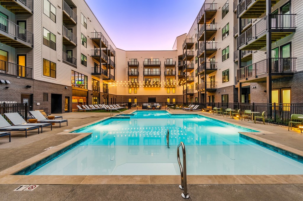 A large outdoor swimming pool in front of apartment buildings.