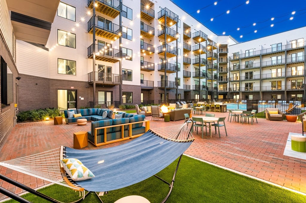 A patio area with a hammock and seating area.