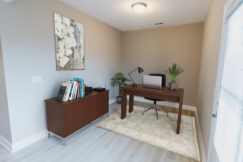 an empty living room with a desk and a tv