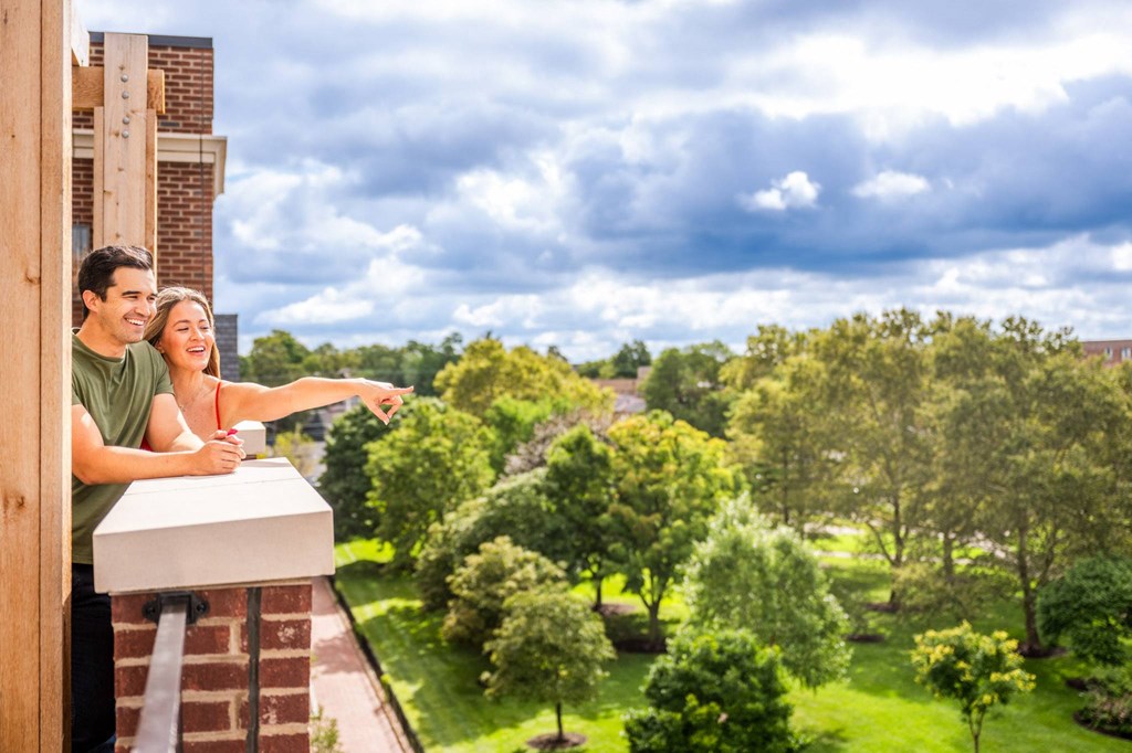 a couple standing on a balcony looking out at the view