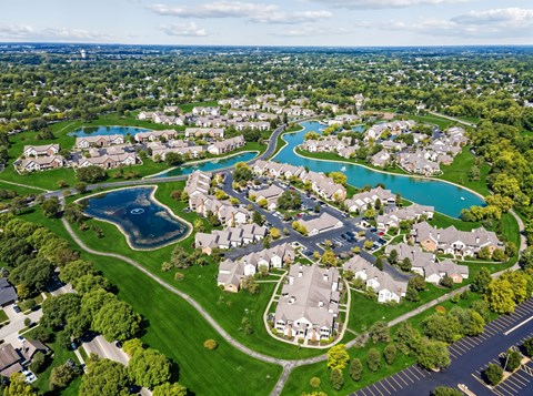 A bird's eye view of a residential neighborhood with a large swimming pool.
