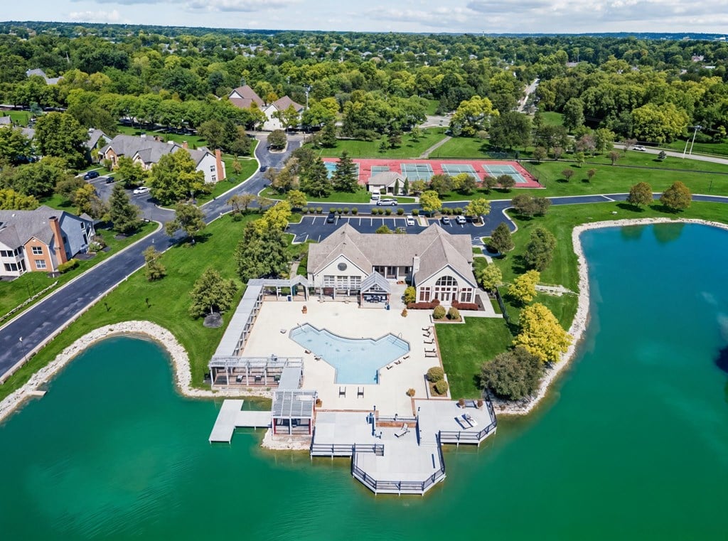 A large house with a pool is surrounded by water.