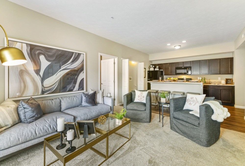 A modern living room with a grey sofa, two armchairs, and a coffee table.