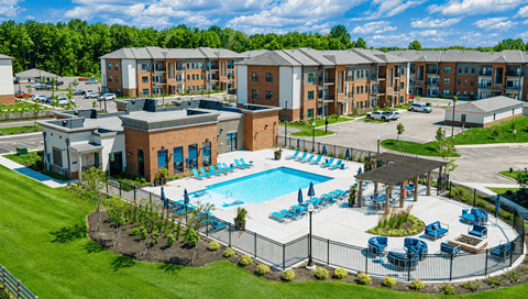 A large building with a pool in front of it.