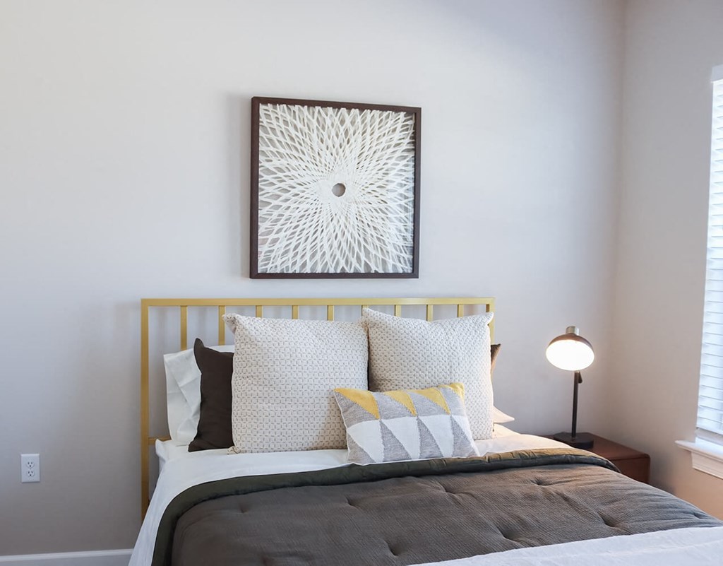 a bedroom with a bed and a painting on the wall