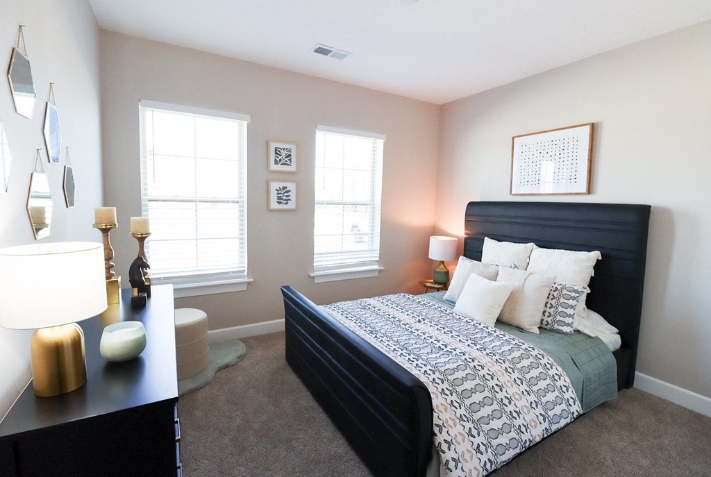 a bedroom with a bed and two windows