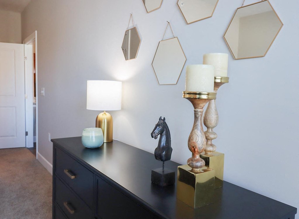 a black dresser with lamps and a horse statue on it