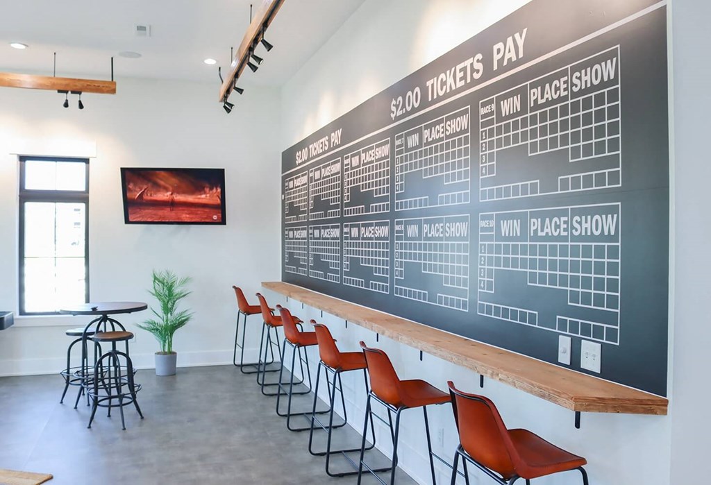 a large chalkboard menu on the wall of a bar with chairs