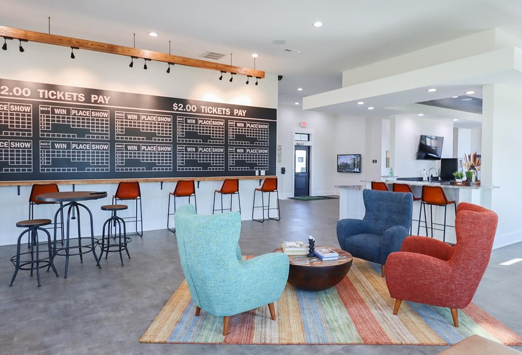 a lobby with chairs and a bar and a large chalkboard