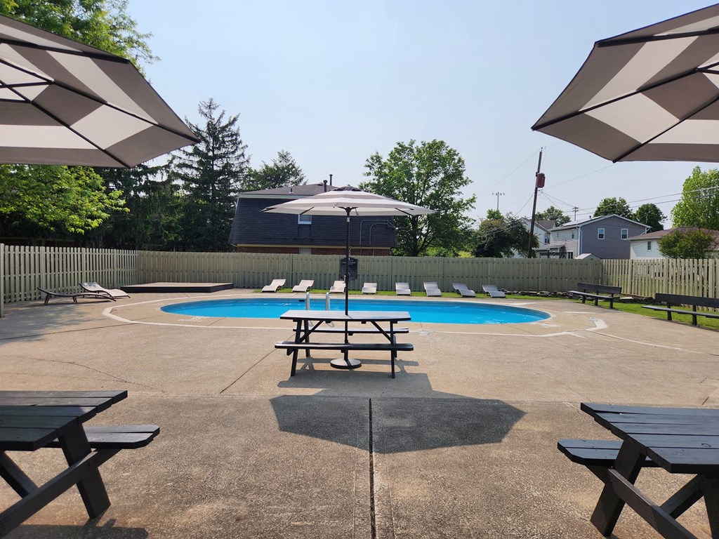 our community has a pool and picnic tables with umbrellas