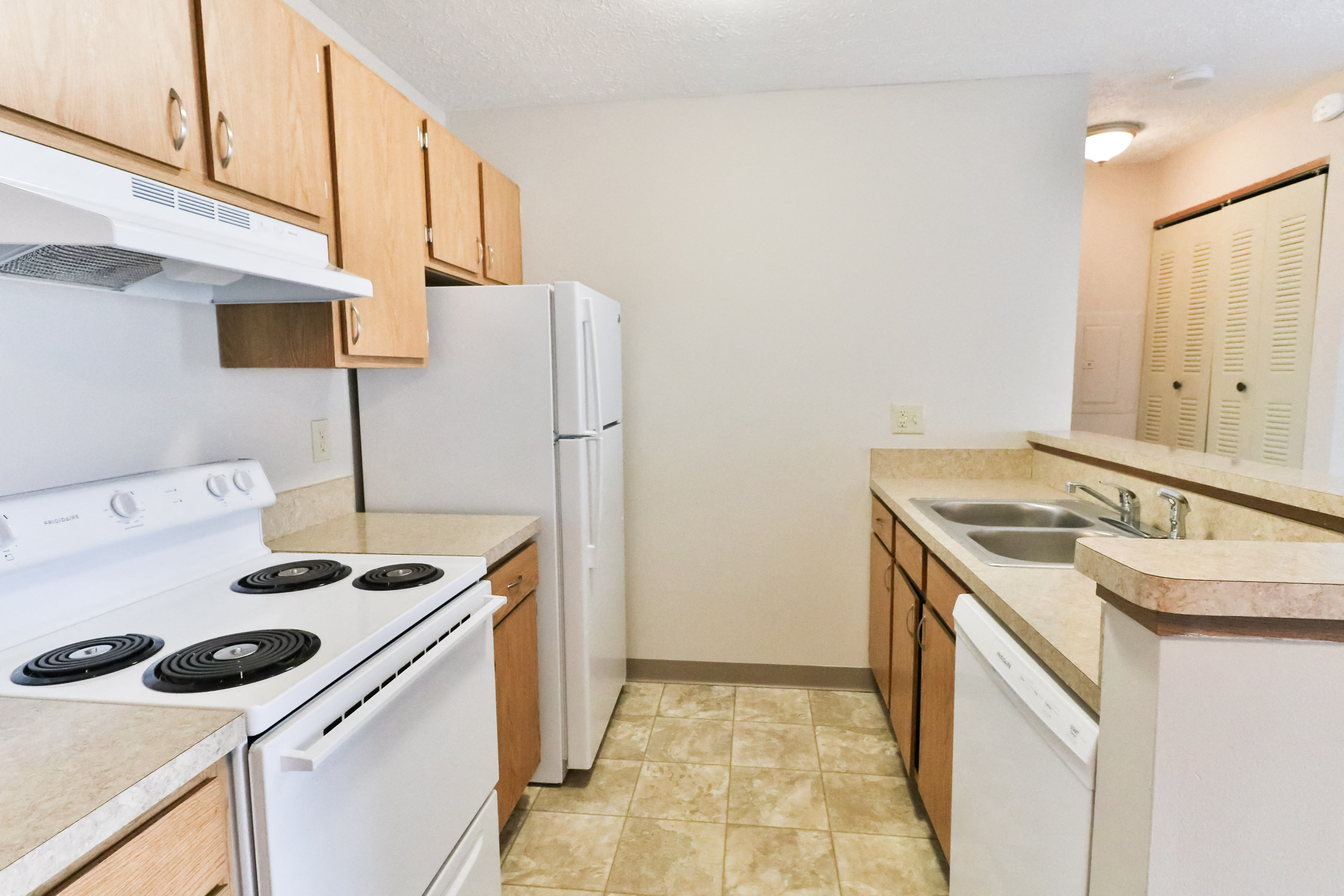 a kitchen with white appliances and wooden cabinets