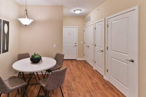 a dining room with a table and chairs and a hallway with white doors