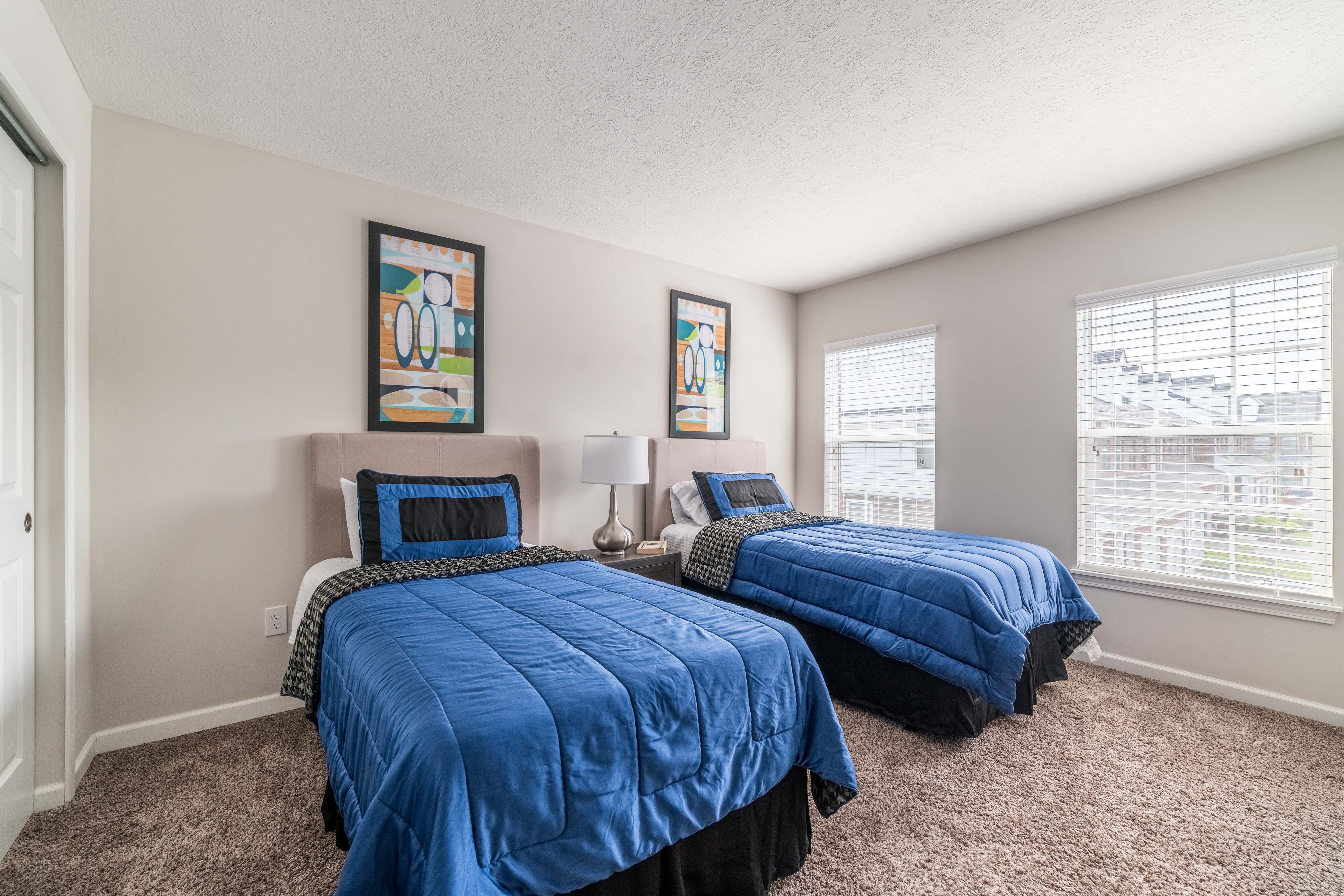 a bedroom with two beds and two windows