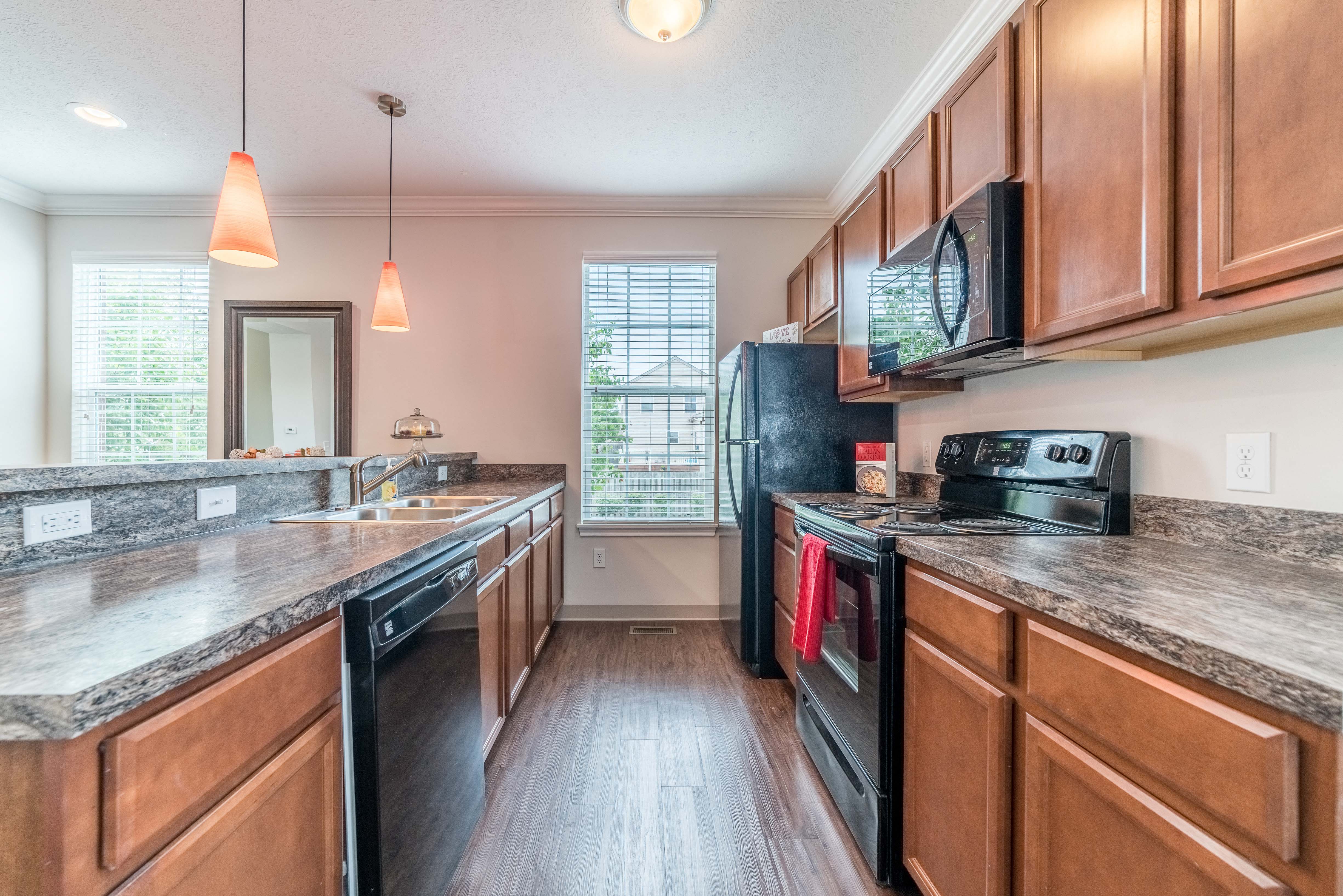 a kitchen with wood cabinets and black appliances and counter tops