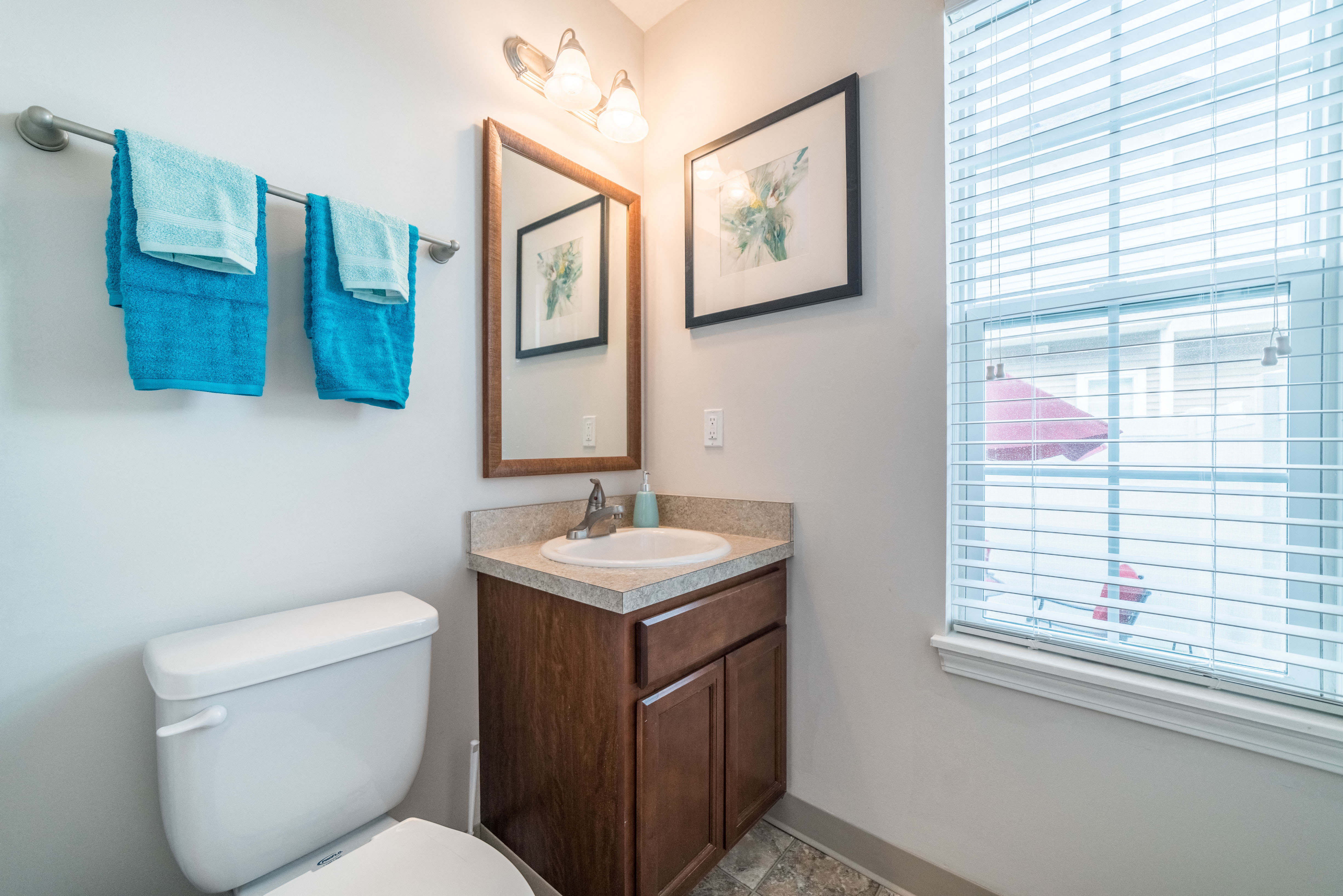 a bathroom with a toilet and a sink and a window